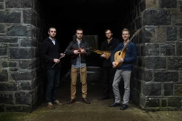 A group of men standing in an alley holding instruments.